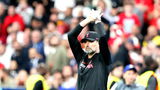 Jürgen Klopp klapt voor de supporters in zijn typische zwarte Liverpool-outfit. De trainer bedankte onlangs voor de functie van bondscoach van Duitsland en koos bewust voor rust na een intensief tijdperk bij The Reds.