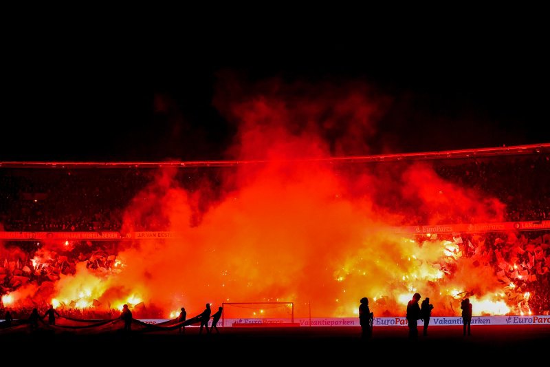 Feyenoord supporters steken vuurwerk af in de Kuip