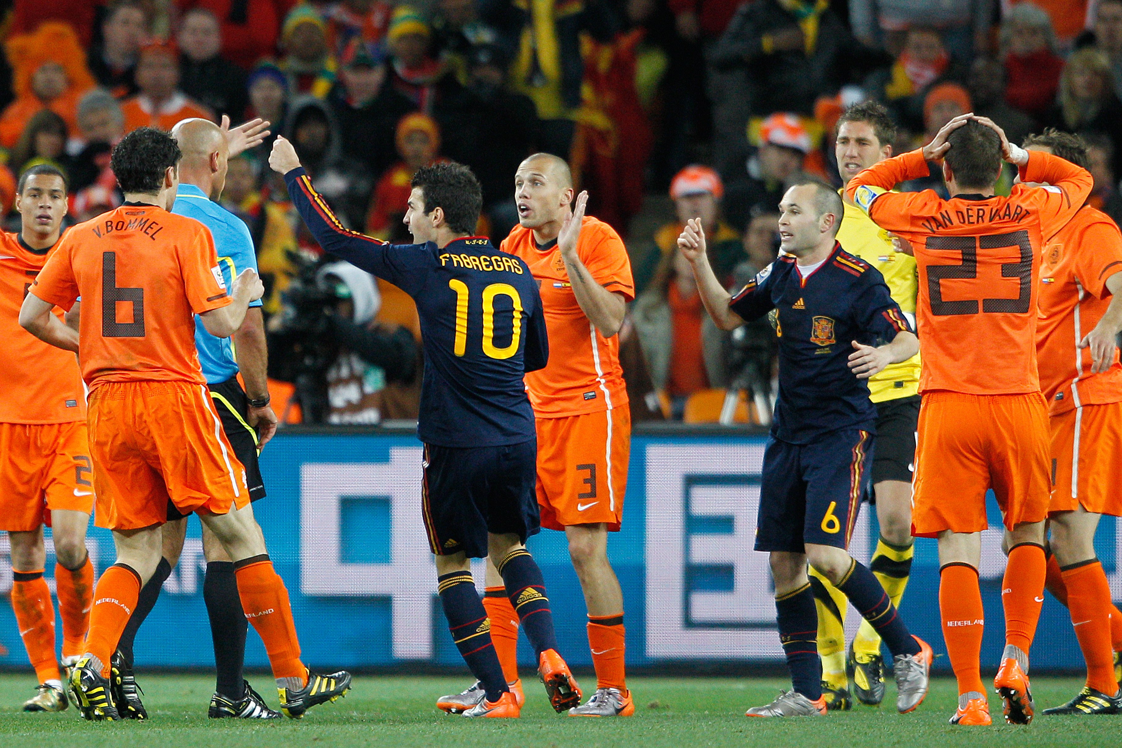 Spaanse internationals Cesc Fàbregas en Xavi Hernández vragen scheidsrechter Howard Webb om een rode kaart voor John Heitinga tijdens de WK-finale van 2010 tussen Nederland en Spanje.