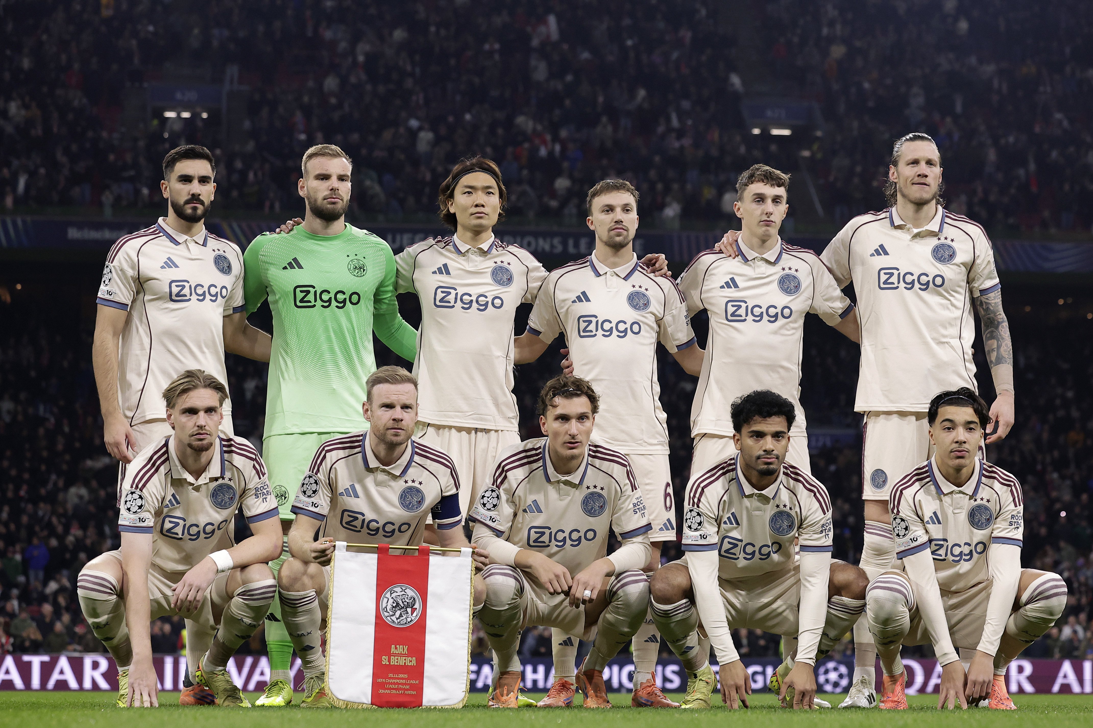 Het Ajax-elftal poseert voorafgaand aan het Champions League-duel met Benfica in de Johan Cruijff Arena. Opvallend: de Amsterdammers dragen het beige derde tenue, verplicht door de UEFA vanwege te weinig kleurcontrast met de Portugese ploeg.