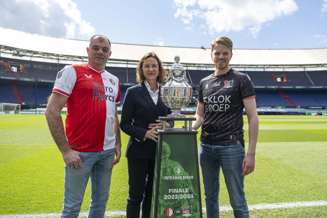 poseren met de knvb beker. marianne van leeuwen omringd door een feyenoord en nec supporter