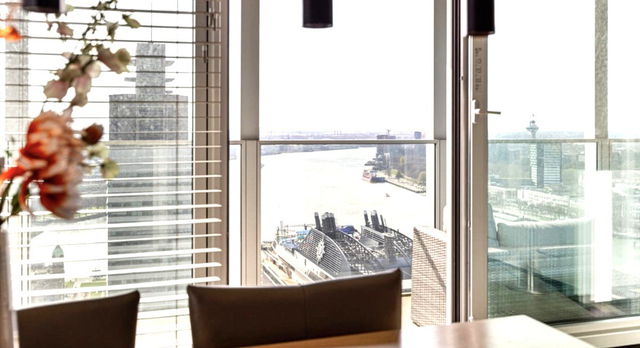 Vanuit de eetkamer van het appartement van Steven Berghuis kijk je uit op de iconische skyline van Rotterdam, met zicht op de Maas, aangemeerde cruiseschepen en de Euromast in de verte. De grote raampartijen zorgen voor een panoramisch uitzicht dat zowel overdag als ’s avonds indrukwekkend is.