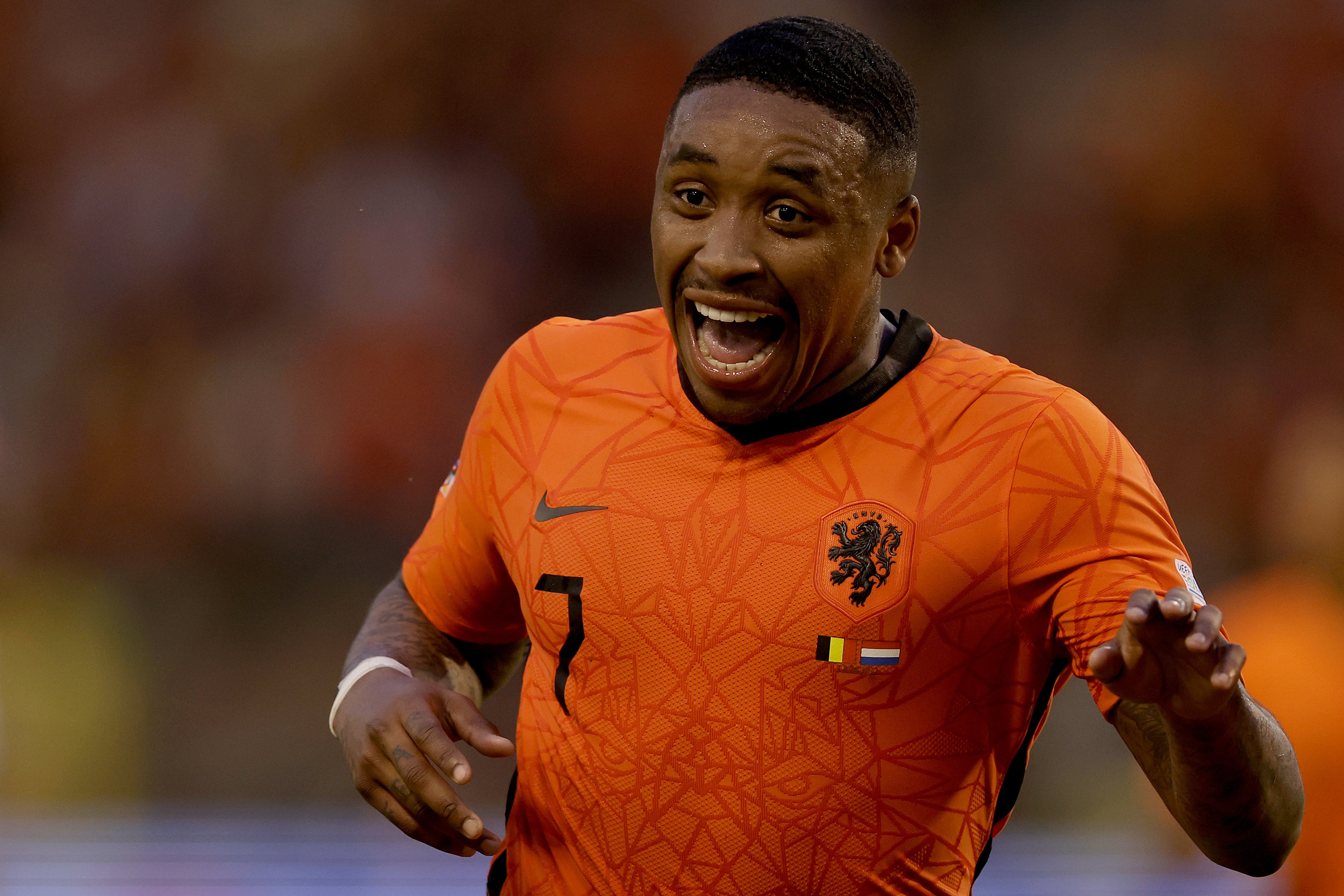 Steven Bergwijn lachend in het shirt van Oranje. De aanvaller zet zijn luxe woning in Amsterdam te koop.