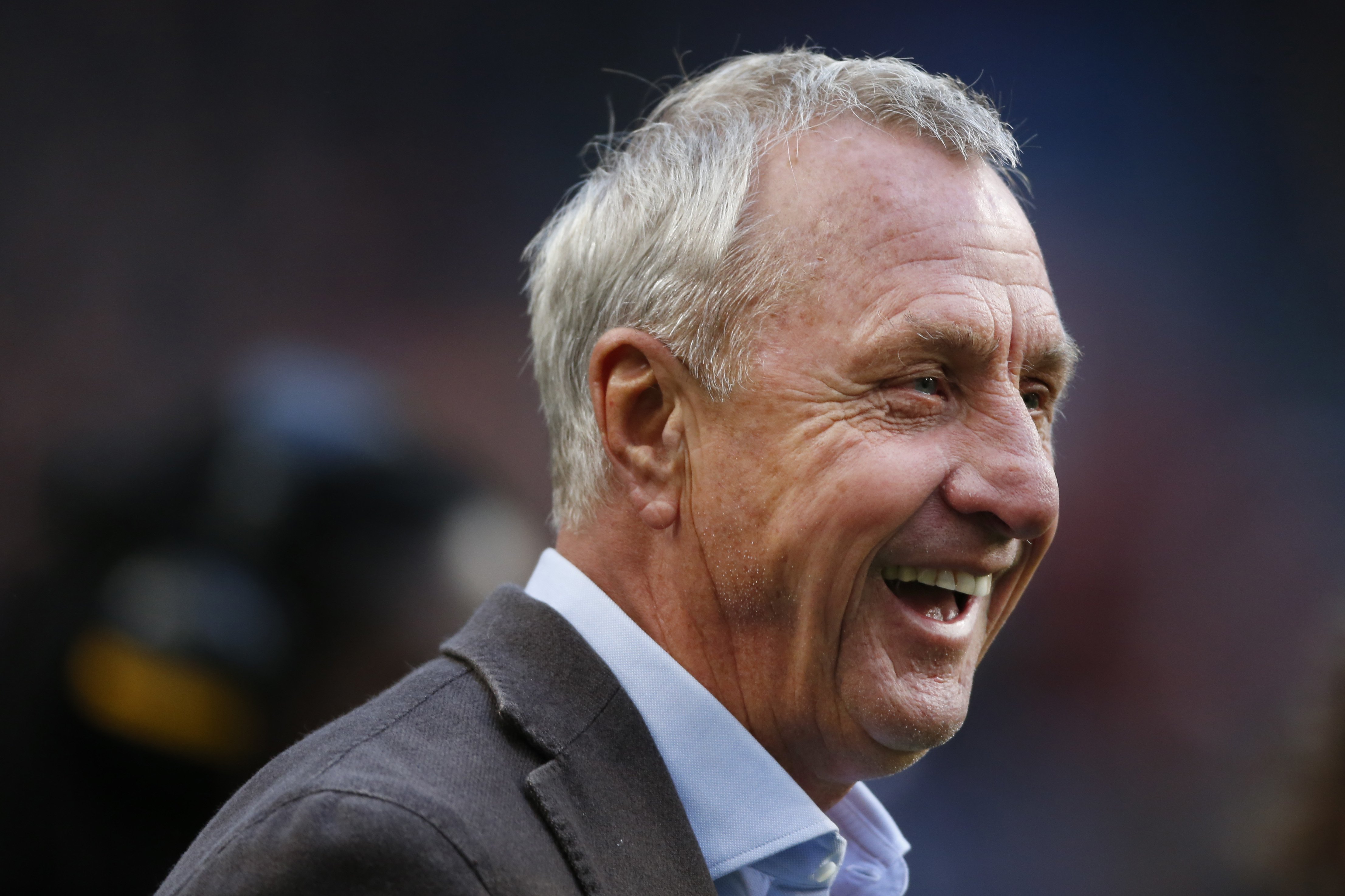 Johan Cruijff tijdens een ontspannen moment langs het veld, symbool voor zijn blijvende invloed op het voetbal.