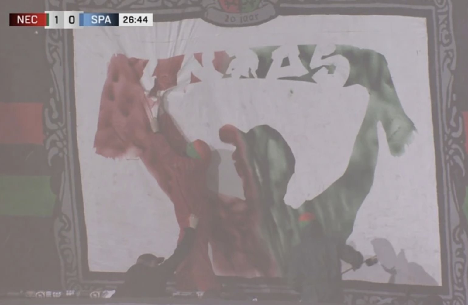 NEC-supporters schilderen live een spandoek op de tribune tijdens de wedstrijd tegen Sparta, een uniek moment dat met luid applaus werd ontvangen.