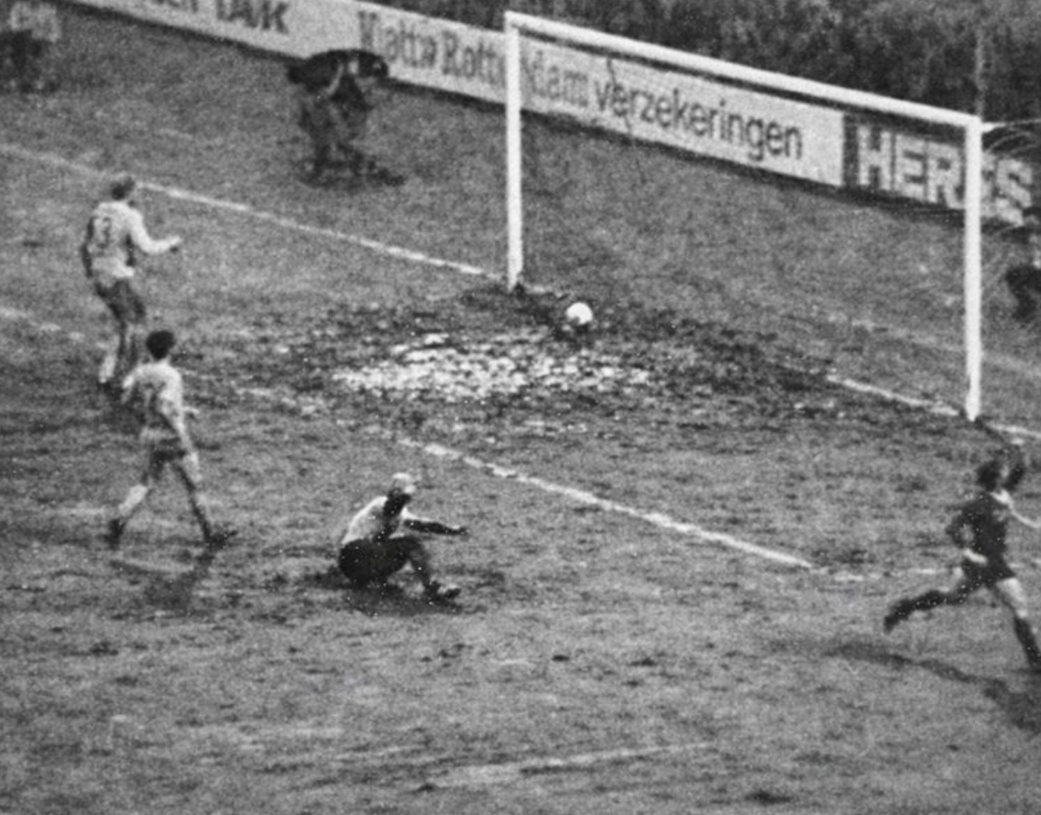 De bal blijft steken in de modder tijdens PSV–Helmond Sport in 1983, terwijl Jurrie Koolhof al juichend wegloopt.
