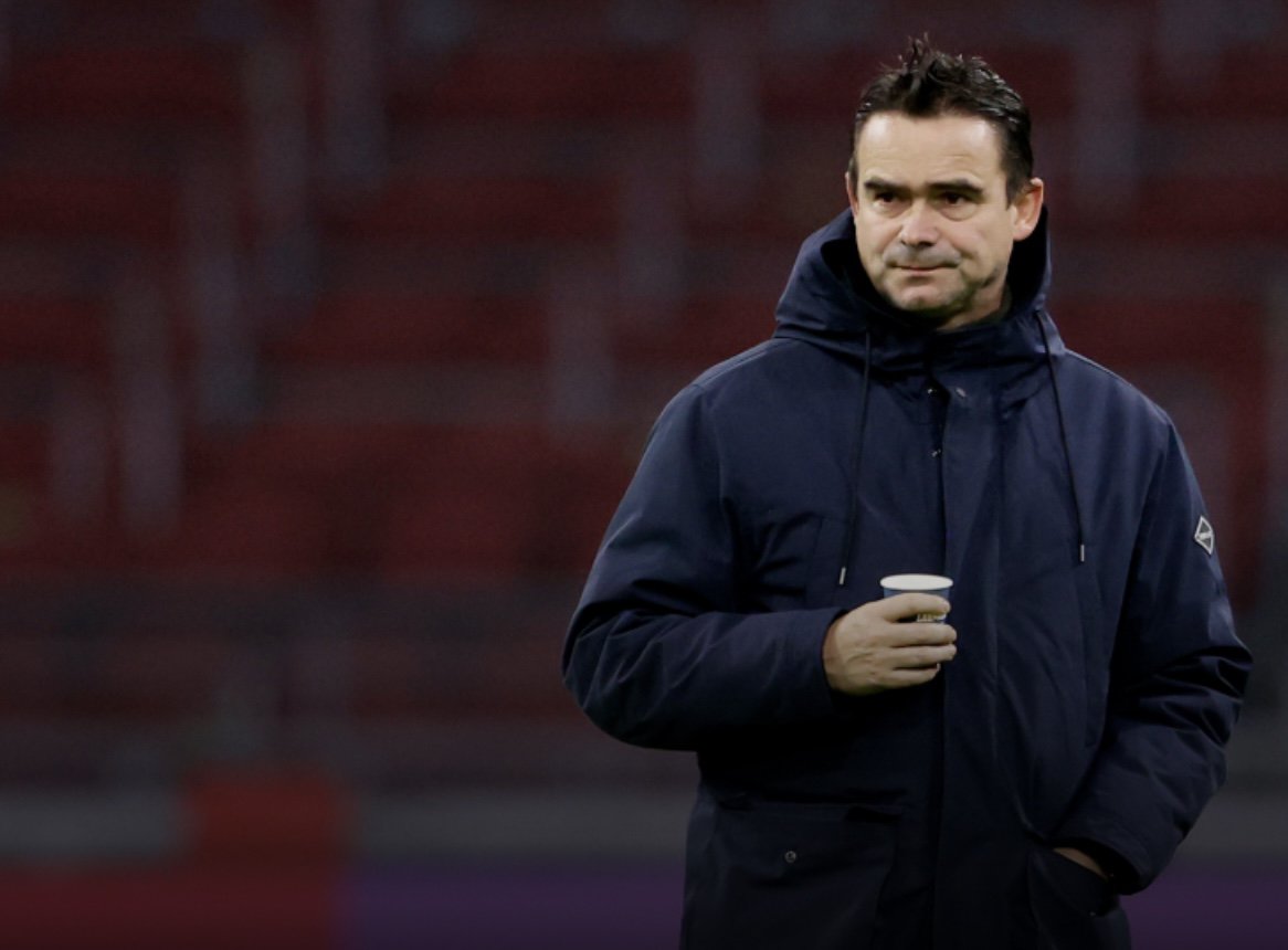 alex kroes vertrekt bij ajax, marc overmars wordt genoemd als opvolger. maar zijn teurgkeer zou op te veel verzet stuiten binnen ajax. overmars op de foto in de arena met een kop koffie in de hand op het veld
